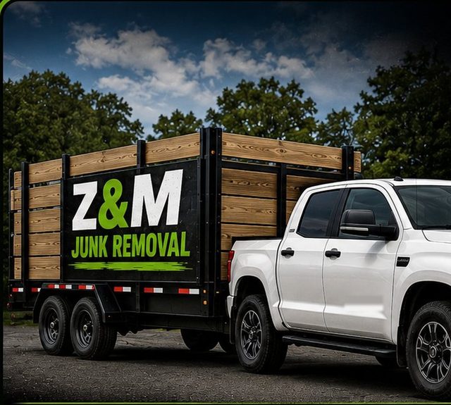 The branded Z&M Junk Removal wood-sided trailer hitched to the company pickup truck